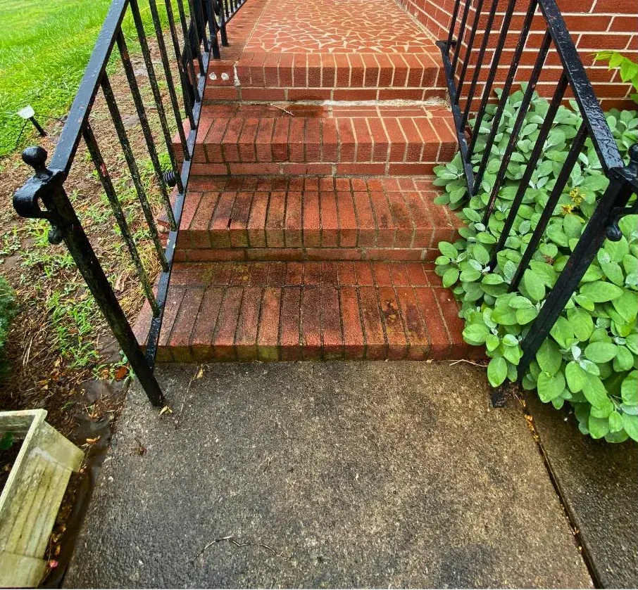 Before: brick entry steps between black railings, the brick dull and the concrete walk dark.